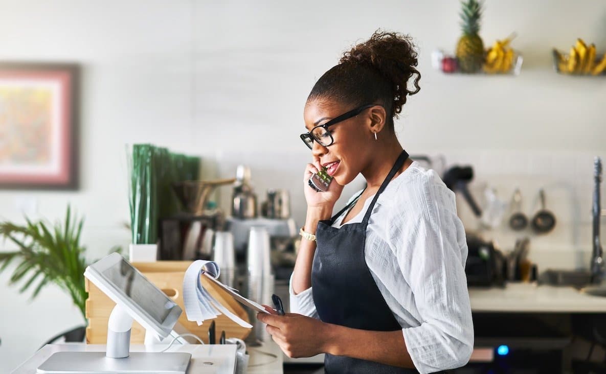 Restaurant staff member confirming booking details by phone