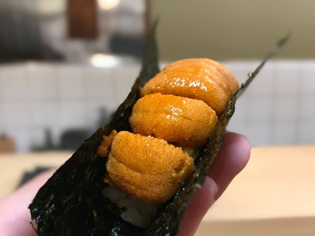Sea urchin sushi held in a sheet of nori