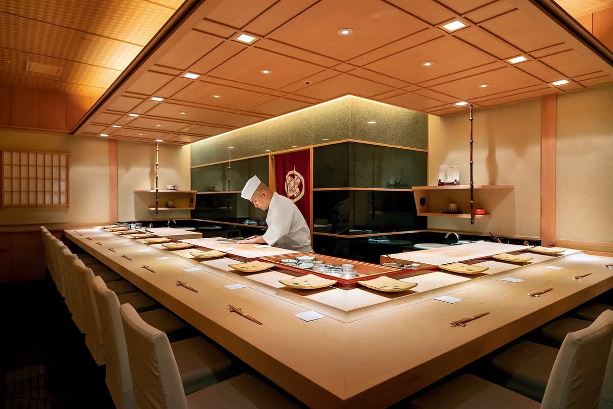 Sushi chef working at a traditional counter with guest seating