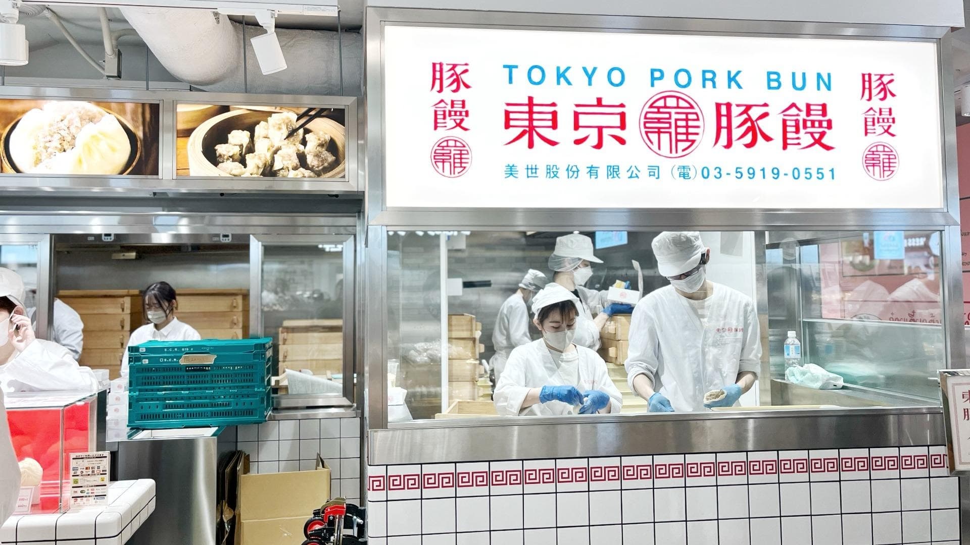 Staff preparing food behind a Japanese food counter