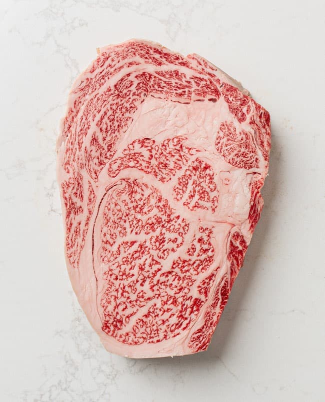 Highly marbled wagyu beef cut shown on a light background